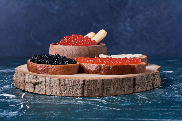 新鲜木板上的红黑鱼子酱烤面包机早午餐传统健康
