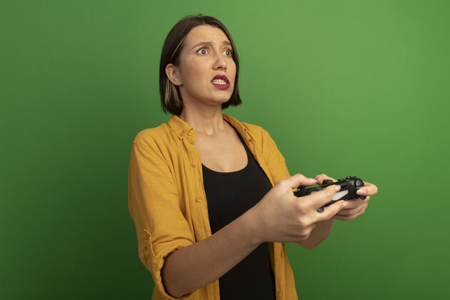 漂亮焦急漂亮的白种女人拿着游戏控制器 看着一旁的孤立无援电子游戏侧控制器