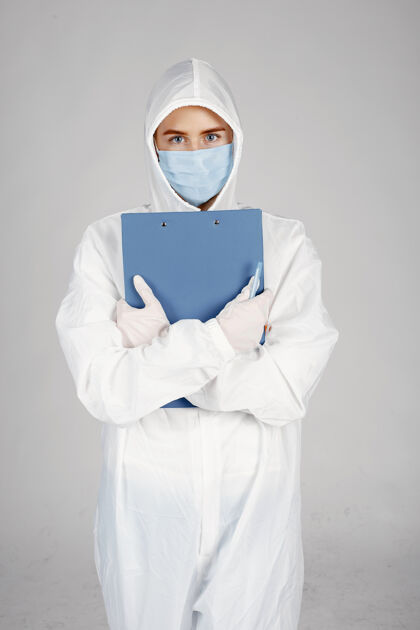 成人戴着医用面罩的医生冠状病毒主题隔离在白墙上穿着防护服的女人从业者医生冠状病毒
