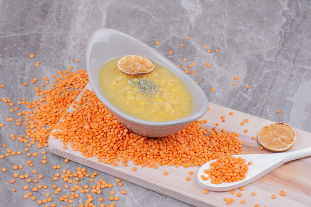 膳食一杯白色的黄色豌豆汤放在木制的盘子里 周围放着红色的小扁豆生的食品传统