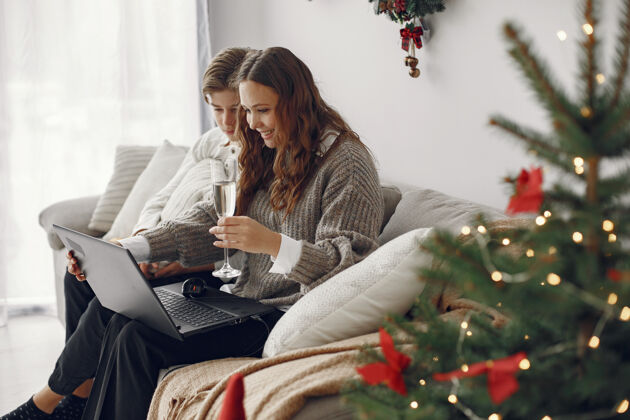 家庭圣诞节在线庆祝圣诞节新年在封锁冠状病毒检疫党在线母亲与儿子设备微笑坐