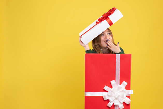 圣诞节正面图年轻女性藏在礼物盒里礼物盒子礼物