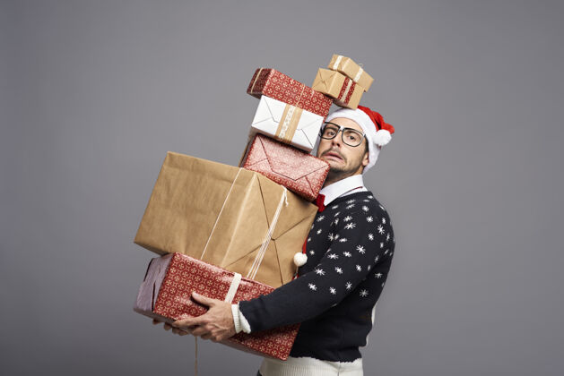 毛衣一个拿着很多圣诞礼物的男人好玩沉重给