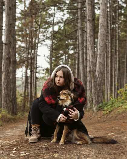 森林在森林里拥抱她的狗的年轻女人愉快和平户外