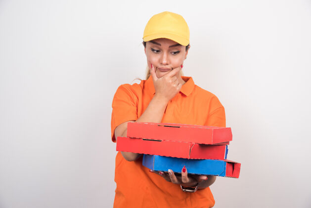 披萨金发女送货员拿着比萨饼盒在白色的空间 而思考的东西手势食物人