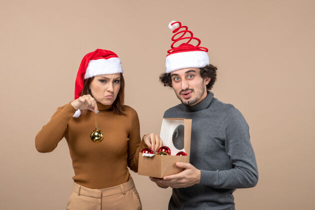 男人喜庆的心情与兴奋有趣可爱的情侣戴着红色圣诞老人帽的灰色镜头帽子圣诞老人镜头