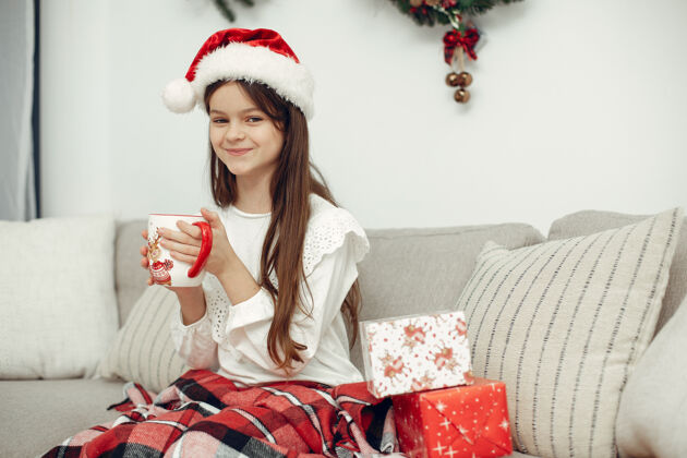 女性穿白色毛衣的孩子坐在圣诞树旁的女儿房间节日女儿