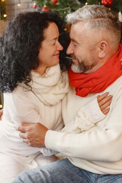 坐着年龄和人的概念家里的老年夫妇穿着白色针织毛衣的女人传统庆典成人