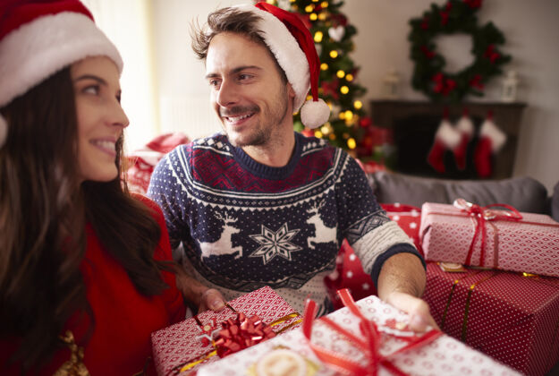 家庭室内圣诞佳节的情侣装饰浪漫露齿的微笑