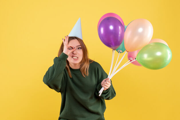 乐趣正面图：带着彩色气球的年轻女性年生日年轻女性