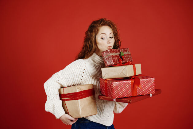 惊喜拿着一堆圣诞礼物的女孩盒子礼品盒脸