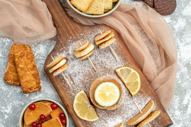 关闭特写镜头简单的煎饼与柠檬在砧板和饼干橙色毛巾蓝色早餐圣诞节食物