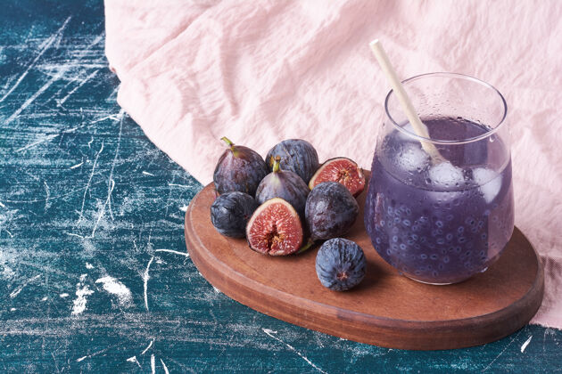 甜紫色无花果配一杯果汁在蓝色上蔬菜质量水果