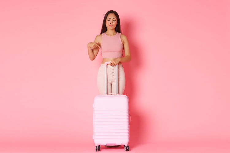 手提箱带着手提箱的年轻女子乐趣指点机场