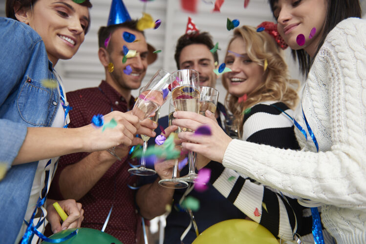 新年前夜在办公室聚会上祝酒五彩纸屑庆祝人