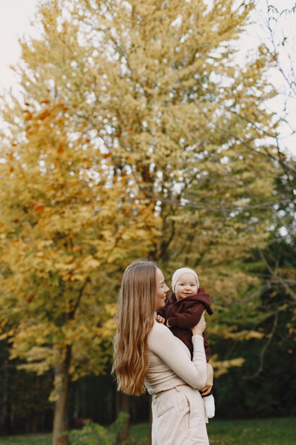 女孩时尚妈妈带着女儿人们走在外面穿着棕色毛衣的女人微笑秋天玩耍