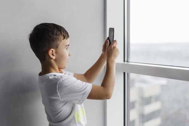 智能手机男孩用手机拍照电话房子数字