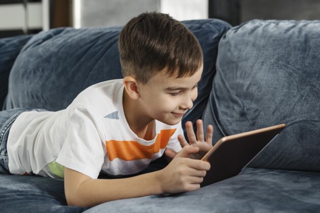 室内男孩家里有人在数字平板电脑上向他挥手孩子个人设备