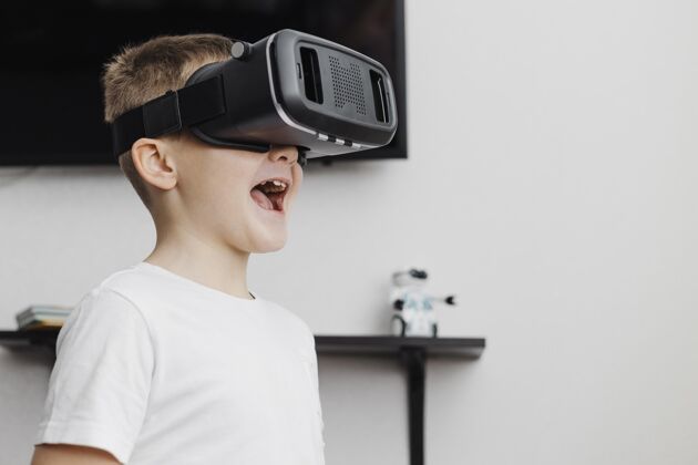 虚拟现实耳机男孩因为使用虚拟现实耳机而快乐设备技术虚拟现实
