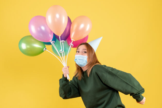 病毒正面图：手持彩色气球的年轻女性飞机生日五颜六色