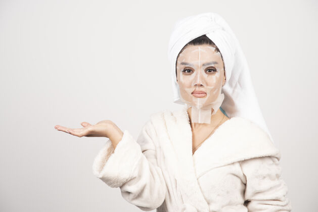 漂亮穿着浴衣和带面罩的毛巾的女人毛巾皮肤人