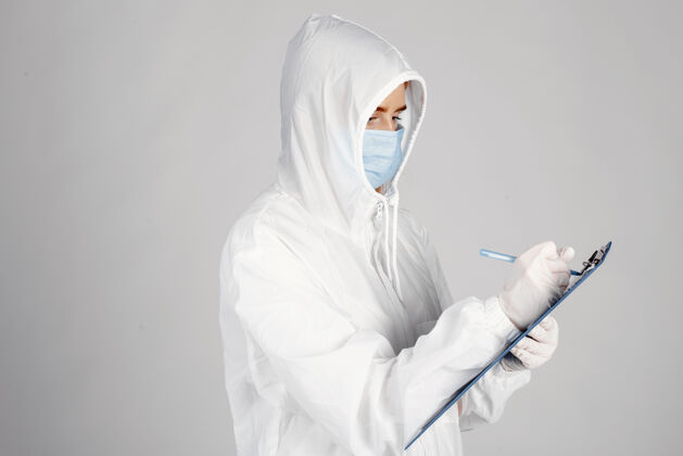 工作戴着医用面罩的医生冠状病毒主题白色背景下隔离穿防护服的女人肖像Covid19制服