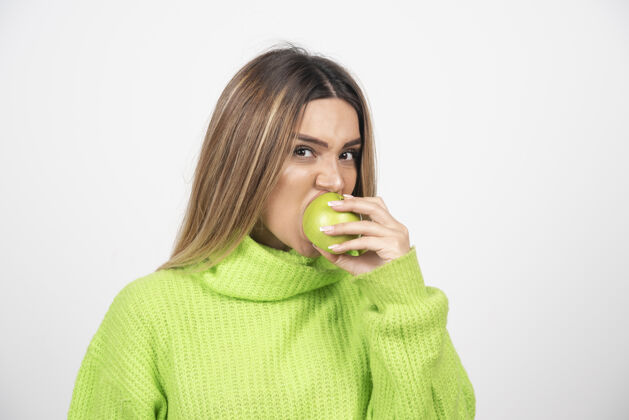 营养穿着绿色t恤的年轻女子正在吃苹果苹果水果表情