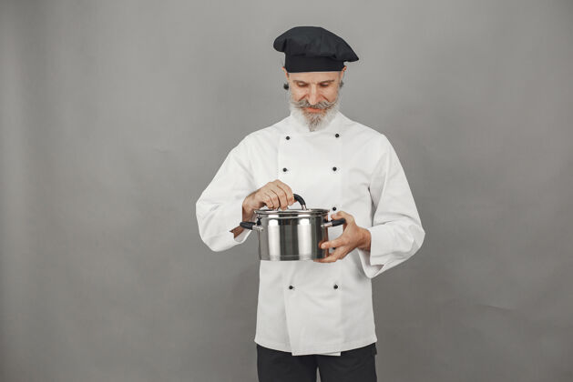 工人高级男子与金属锅厨师在一个黑色的帽子专业的方法来处理业务专业人人