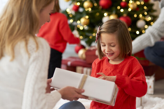 孩子一家人从打开礼物开始过圣诞节节日给予圣诞装饰