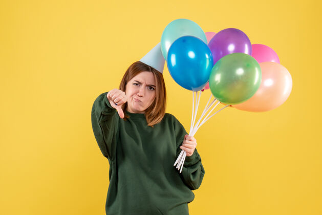 乐趣正面图是一位年轻的女士 手里拿着五颜六色的气球聚会年轻的女人快乐