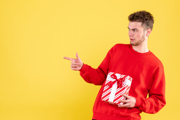 年轻正面图：穿着红色衬衫的年轻男性 带着圣诞礼物礼物圣诞节成人