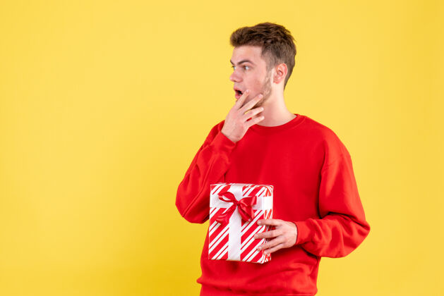圣诞节正面图：穿着红色衬衫的年轻男性 带着圣诞礼物艺人人衬衫