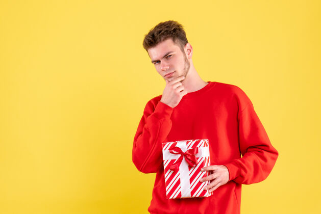 成人正面图：穿着红色衬衫的年轻男性 带着圣诞礼物圣诞节衬衫颜色