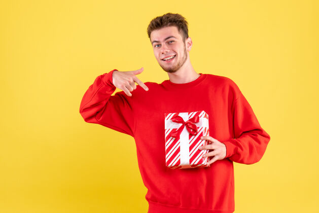 情感正面图：穿着红色衬衫的年轻男性 带着圣诞礼物衬衫礼物肖像