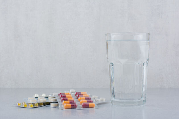 保健各种包装的胶囊和药丸 还有一杯水医疗药丸水