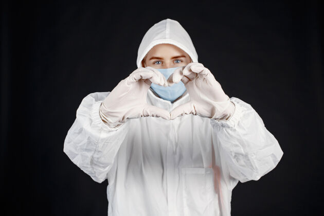 医生戴着医用面罩的医生冠状病毒隔离在黑墙上穿着防护服的女人冠状病毒医院临床
