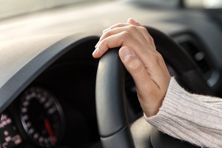 航行侧视图的妇女在她的车举行方向盘 而驾驶方向盘方向盘冒险