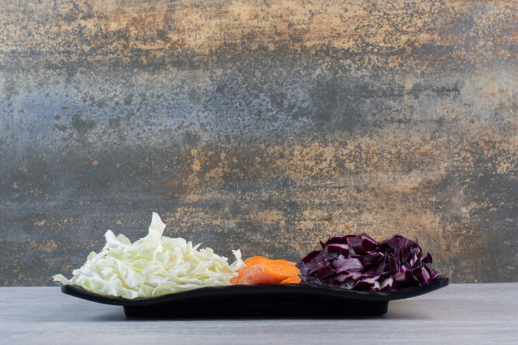 生的切碎的胡萝卜 红白的卷心菜放在黑盘子里高质量的照片有机健康天然