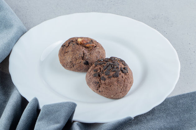 桌布巧克力饼干放在白色盘子里 靠近大理石背景上的桌布饼干调味品薯片