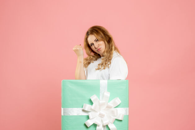 年轻女性正面图：站在蓝色礼品盒内的年轻女性粉色盒子颜色