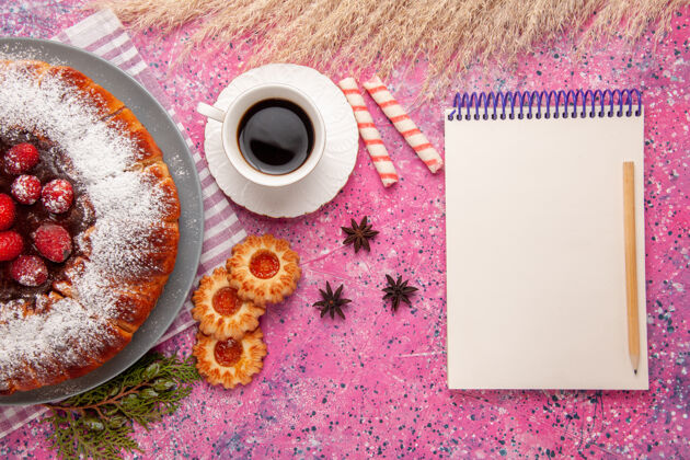 顶部俯瞰美味的草莓蛋糕糖粉配上一杯茶和饼干 背景为浅粉色蛋糕甜饼干茶视图灯光草莓