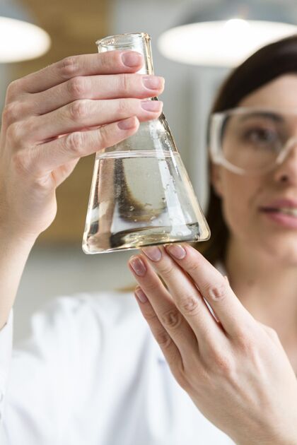 化学家女科学家戴着安全眼镜拿着试管在实验室里女人试管科学家