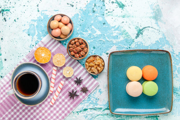 面粉俯瞰一杯咖啡 配上法国马卡龙葡萄干和淡蓝色桌上蛋糕 烘焙甜甜甜饼饼干饼干烤化妆