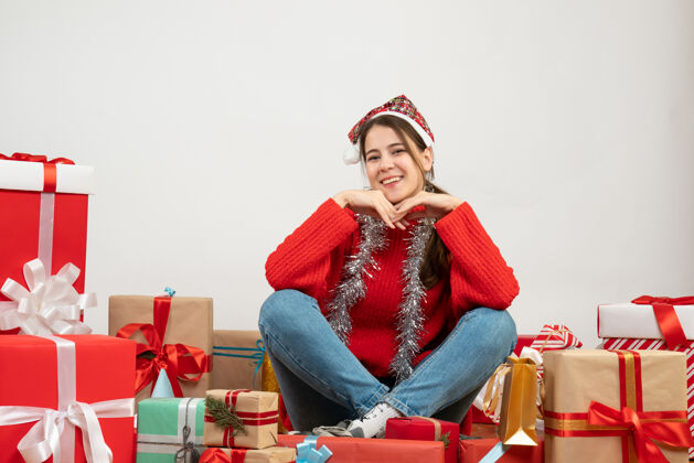 圣诞节戴着圣诞帽的年轻女孩围坐在白色的礼物旁边衣服时尚礼物