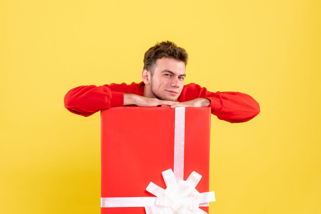 雪正面图穿红衬衫的年轻男子坐在礼品盒内年轻盒子颜色