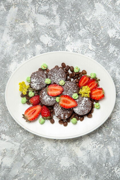 生的俯瞰美味的巧克力蛋糕与新鲜草莓的白色表面饼干糖蛋糕甜茶饼干可食用的水果可食用的黑莓