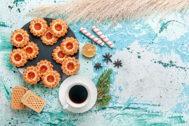 杯子俯瞰美味的小饼干与华夫饼和咖啡杯上的蓝色办公桌饼干饼干甜糖的颜色饼干顶部少量