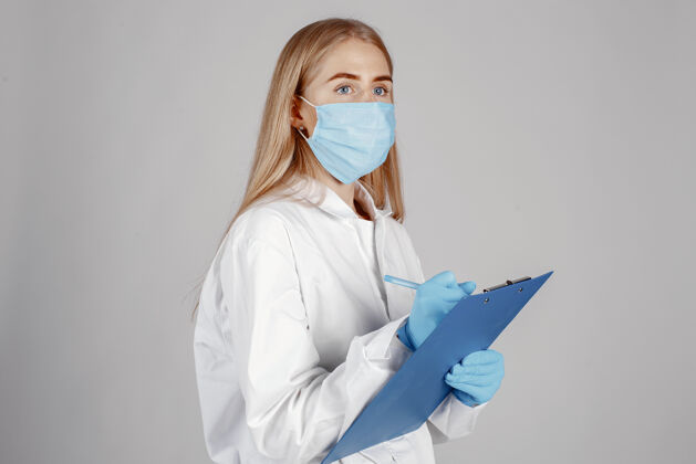 手套戴着医用面罩的医生冠状病毒隔离在白墙上职业制服医院