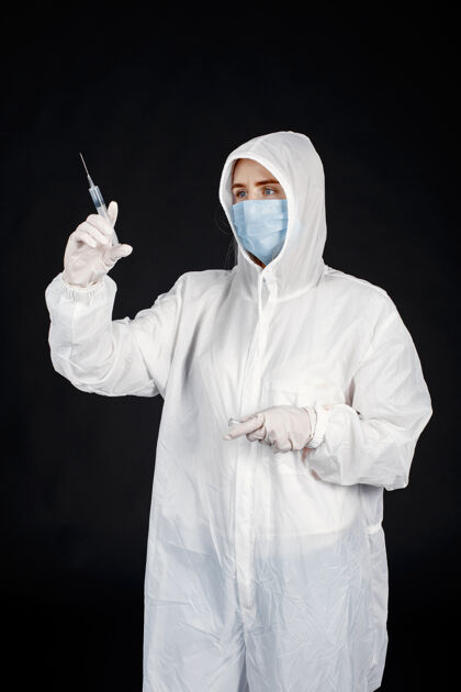 从业者戴着医用面罩的医生冠状病毒隔离在黑墙上穿着防护服的女人医生诊所医生