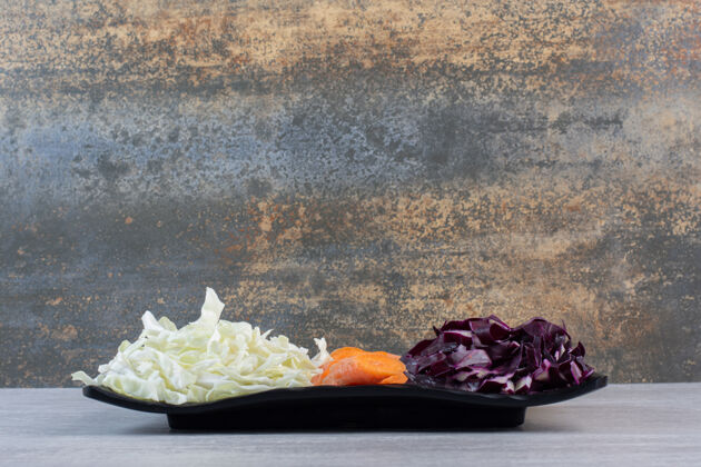 生的切碎的胡萝卜 红白的卷心菜放在黑盘子里高质量的照片有机健康天然